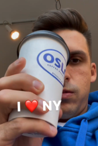 Cody holding a coffee cup with the caption "I <3 NY"