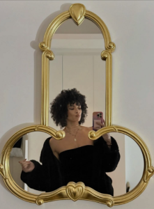 Hannah Frankson posing in front of a mirror. Named Funniest Without Trying for 2025 Peloton Instructor Superlatives