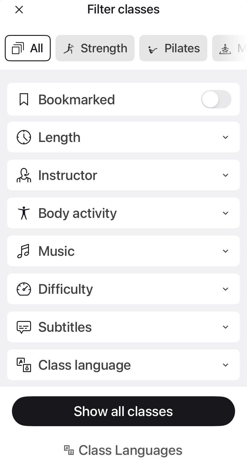Peloton class language filter screen showing toggle controls for English, German, and Spanish instruction with subtitle options on a mobile device.