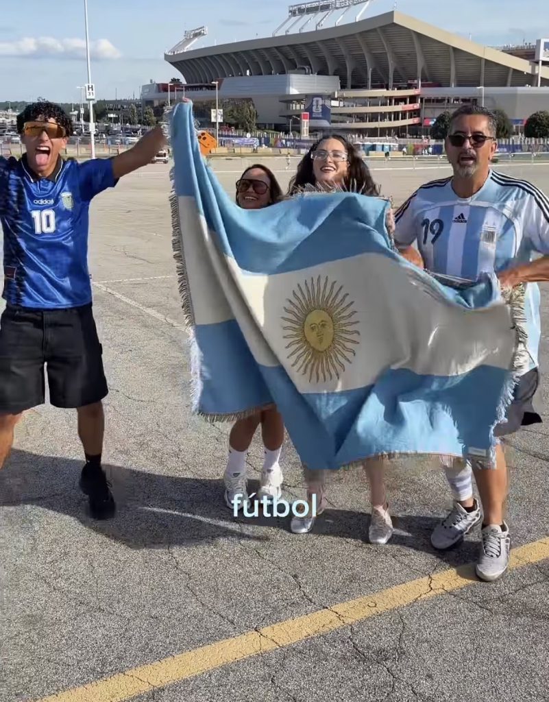 Camila Ramón wrapped in an Argentina flag with family outside a World Cup stadium