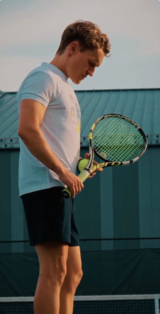 Train for Tennis program instructor Matt Wilpers checks his grip before serving
