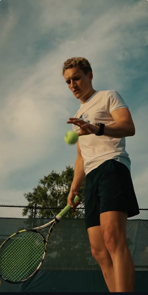Train for Tennis program instructor Matt Wilpers bounces the ball before a serve