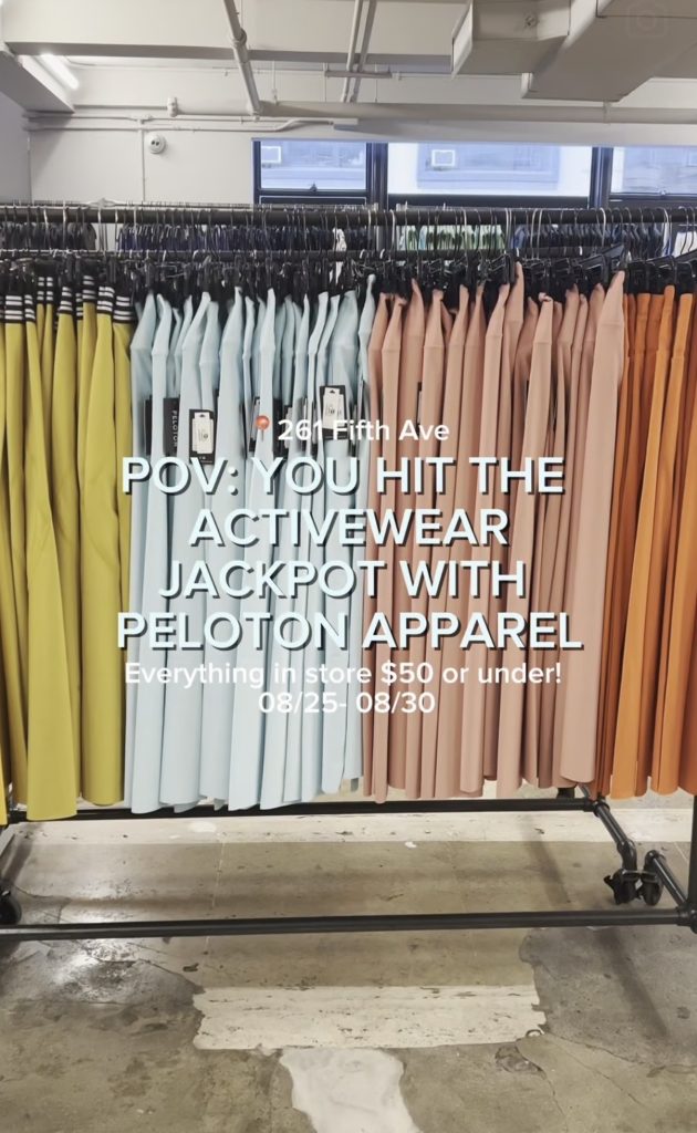 Peloton Apparel sample sale rack of yellow, blue, and orange tops priced at $50 or under