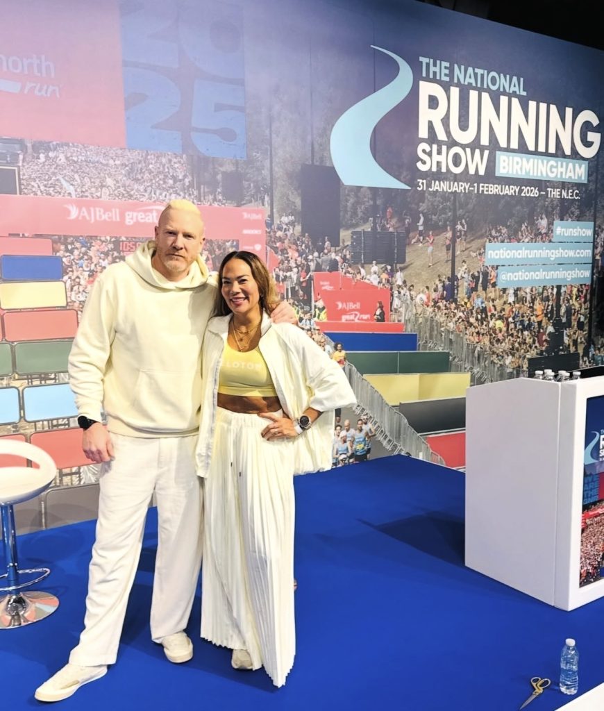 National Running Show co-hosts Susie Chan and Iwan pose at the Birmingham NEC show backdrop