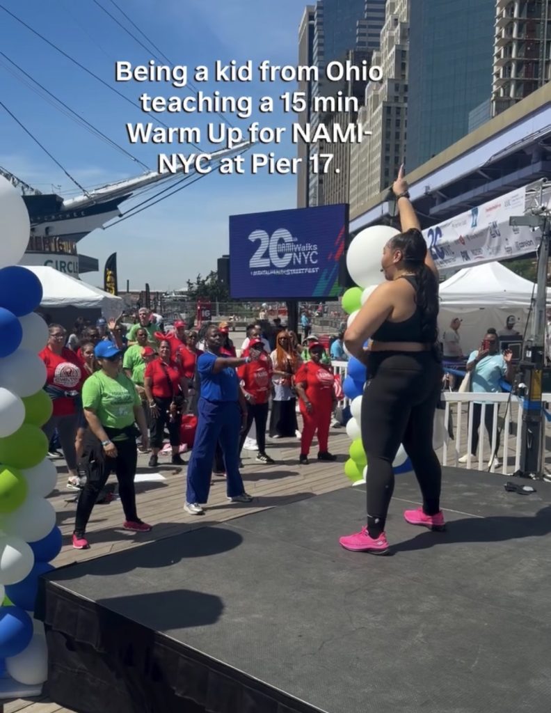Suicide prevention month advocate Ash Pryor teaching a warm up for NAMIWalks NYC at Pier 17.