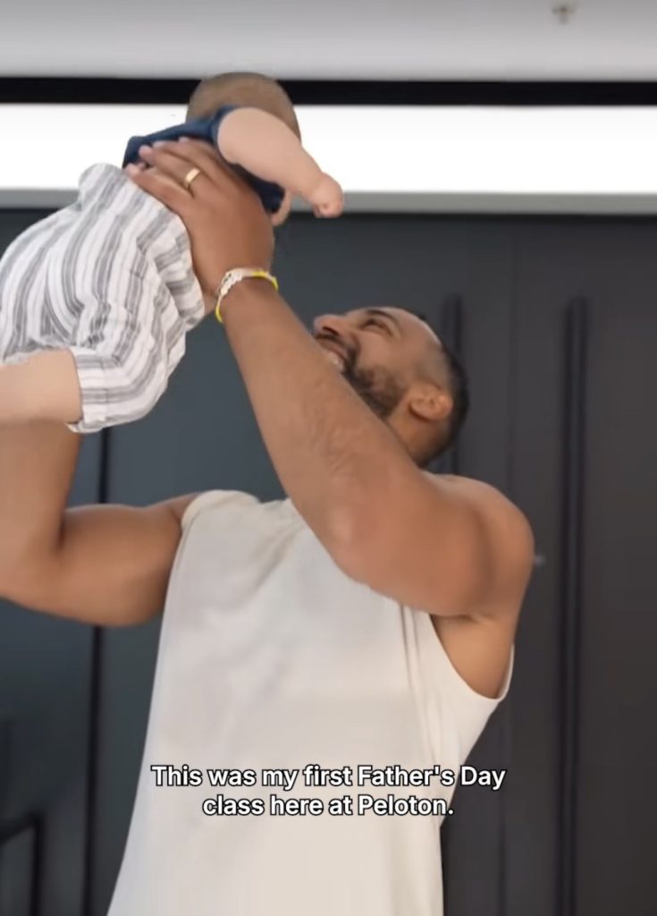 Jermaine Johnson Peloversary scrapbook photo of Jermaine lifting his baby at his first Father's Day class