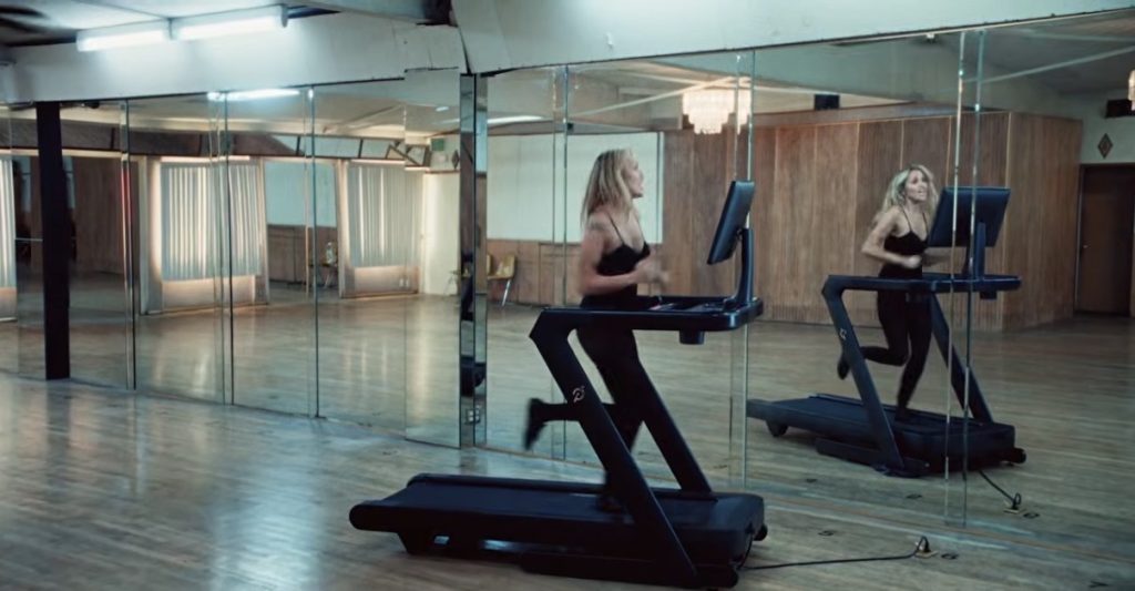 Miley Cyrus Peloton ad scene of Miley running on the Peloton Tread in front of studio mirrors