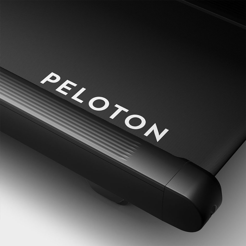 Peloton Tread Flex belt and side rail in a close-up with the Peloton logo