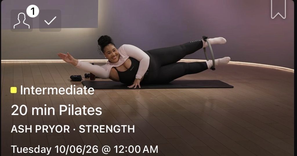 Ash Pryor Pilates class, Ash lying on a mat holding a Pilates circle to her lifted feet