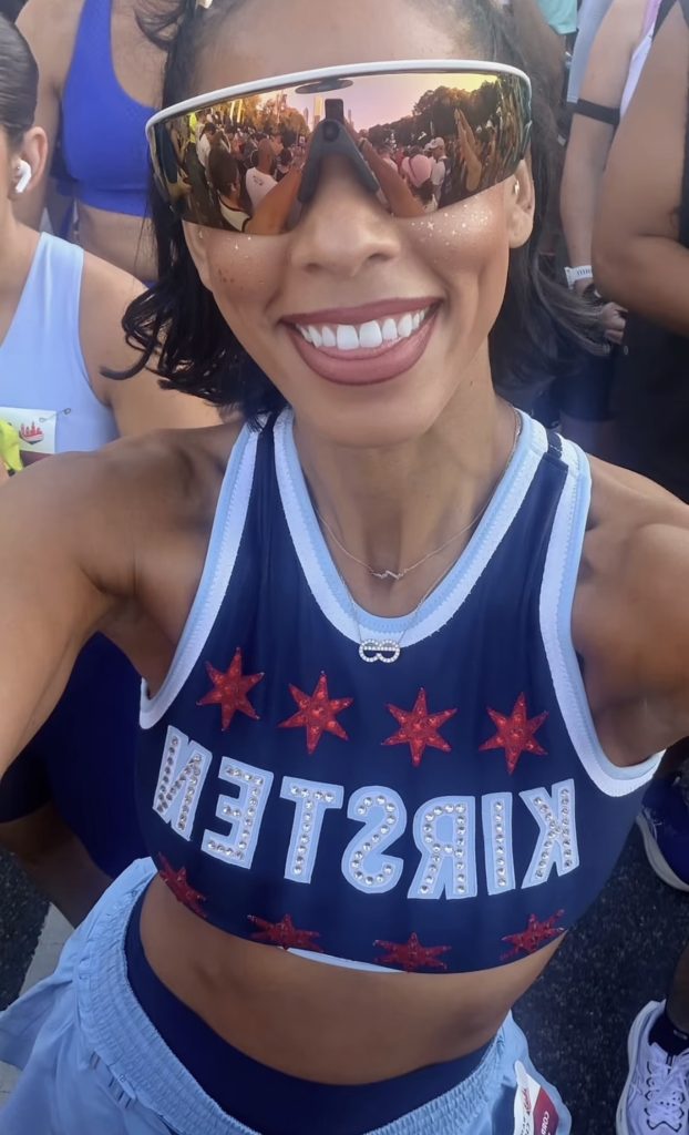 Peloton instructors race weekend Kirsten Ferguson celebrating her Chicago Marathon PR with the skyline behind her