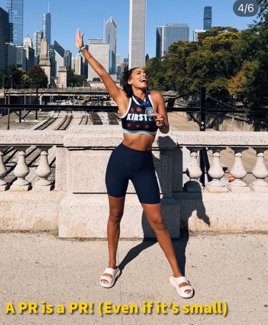 Peloton instructors race weekend Kirsten Ferguson celebrating her Chicago Marathon PR with the skyline behind her