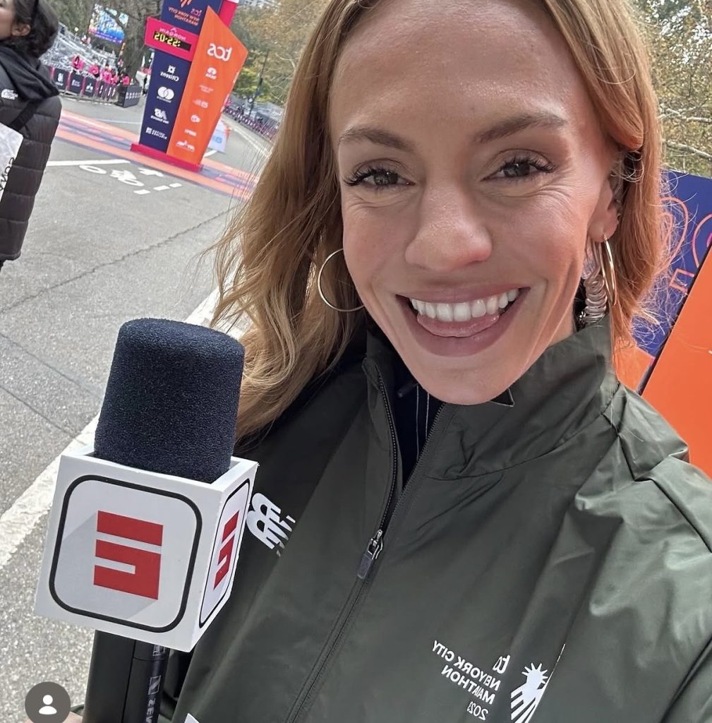 Becs Gentry NYC Marathon selfie with an ESPN microphone near the finish line during her 2023 broadcast debut