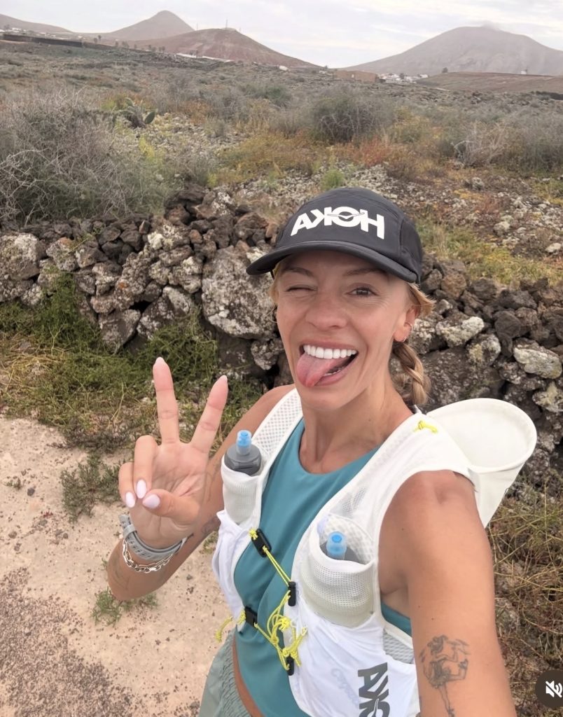 Becs Gentry Hoka trail run selfie in a Hoka cap and hydration vest