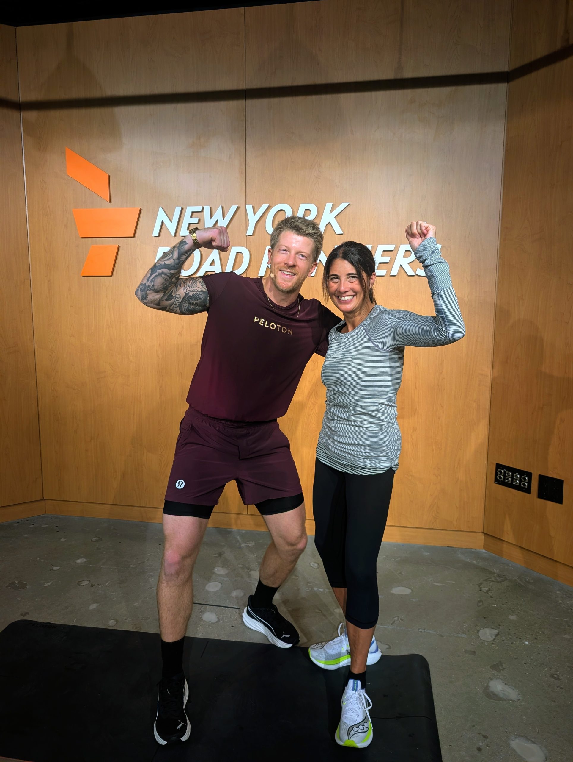 Logan Aldridge posing for a photo with an attendee at the NYRR Run Center